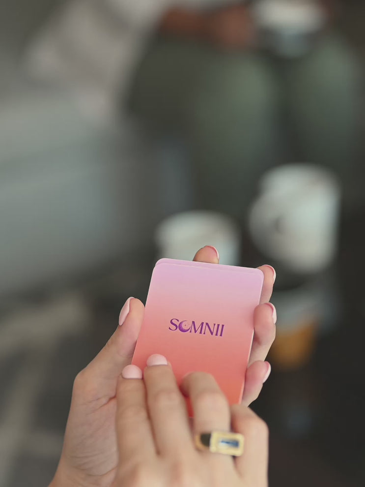 A mom turning a Somnii Says conversation card saying 'you can love your child and dislike parenting. 