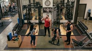 People training in a weightlifting gym, highlighting the traditional use of creatine monohydrate before Somnii reformulated it specifically for women and moms.