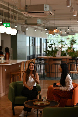 Building a mother's village: Somnii's founders connecting in a bright workspace, highlighting the importance of social support and shared experiences in maternal mental health