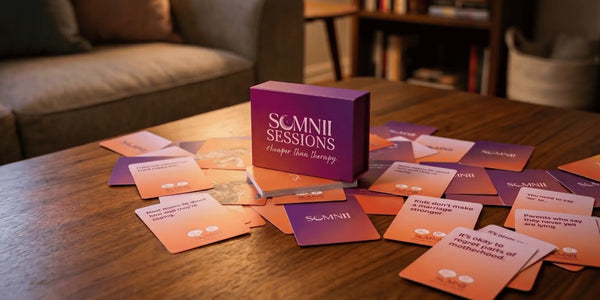 Somnii Sessions conversation card game box and scattered prompt cards on a wooden table