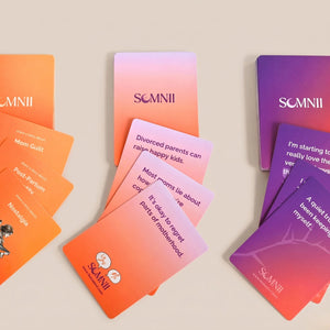 Three fan-spread decks of Somnii Sessions cards featuring prompts on 'Mom Guilt,' 'Post-Partum Identity,' 'Nostalgia,' and the complexities of motherhood and divorce