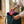 A mom placing the Somnii Sessions card game box into a teal leather tote bag, highlighting the portable design of these conversation cards for moms on the go.